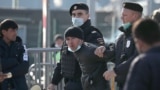 Police officers detain a foreign citizen outside Moscow's Multifunctional migration center.