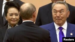 Президенты Нурсултан Назарбаев (справа) и Владимир Путин (стоит спиной) на саммите Совещания по взаимодействию и мерам доверия в Азии. Шанхай, 20 мая 2014 года.