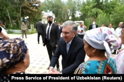 Өзбекстан президенті Шавкат Мирзияев (ортада) Қарақалпақстан астанасында жергілікті тұрғындармен кездесіп тұр. Нөкіс, 3 шілде 2022 жыл. Өзбек президенті баспасөз қызметі таратқан фото.