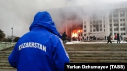 Протестующие возле горящего здания акимата. Участники протеста против роста цен на топливо ворвались в здание акимата и подожгли его. Алматы, 5 января 2022 года
