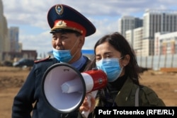 Сотрудница акимата в сопровождении полицейского. Нур-Султан, 12 сентября 2021 года