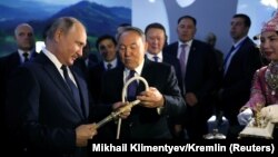 Президент России Владимир Путин и его казахстанский коллега Нурсултан Назарбаев во время посещения туристической выставки в рамках межрегионального форума. Петропавловск, 9 ноября 2018 года.