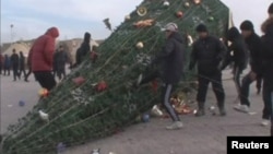 Упавшая елка на центральной площади в городе Жанаозен, Мангистауской области. 16 декабря 2011 года.