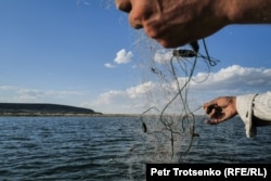 Нуржан закидывает в море рыболовную сеть. Кызылординская область, 3 июля 2024 года