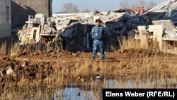 Полицейский стоит возле рухнувшего дома в новом микрорайоне Бесоба. Караганда, 7 апреля 2012 года. 