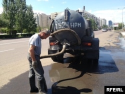 Цистерналы көлікпен су сорып тұрған жұмысшы. Астананың сол жағалауы, 2 тамыз 2013 жыл.