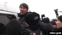 Полиция задерживает одного из участников митинга против девальвации. Алматы, 16 февраля 2014 года.