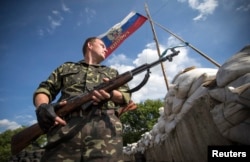 Пророссийский сепаратист стоит на КПП у города Лисичанск. 24 июня 2014 года.