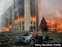 Сгоревший автомобиль возле горящего здания акимата Алматы. 5 января 2022 года