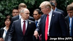 Президент России Владимир Путин (слева) и президент США Дональд Трамп идут для съемок совместной фотографии участников саммита АТЭС. Дананг. 11 ноября 2017 года.