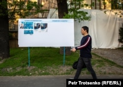 Қазақстан президенттігіне кандидаттар Қасым-Жомарт Тоқаев пен Амангелді Таспиховтың сайлау жарнамалары ілінген жерден өтіп бара жатқан адам. Алматы, 13 мамыр 2019 жыл.