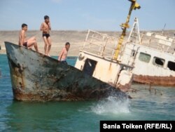 Дети на заброшенной лодке на берегу Каспийского моря. Поселок Баутино. 3 мая 2013 года. Иллюстративное фото.