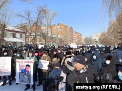 На митинге в Уральске протестующий держит плакат "Назарбаев - диктатор". 28 февраля 2021 года.