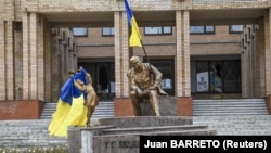 Украинские флаги и памятник Тарасу Шевченко в центре Балаклеи, города в Харьковской области, освобожденного от российских войск