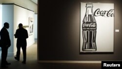 Люди стоят возле вывески логотипа компании Coca Cola. Иллюстративное фото.