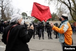 Люди держат красные трусы во время акции протеста против предполагаемой причастности российских спецслужб к взрыву на складе боеприпасов в районе Врбетице в 2014 году у посольства России в Праге, Чешская Республика, 18 апреля 2021 года.