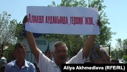 Участник акции протеста в защиту местного предпринимателя держит плакат с надписью, которая в переводе на русский язык означает: «В Алакольском районе героина нет». Ушарал, Алматинская область, 23 мая 2011 года.