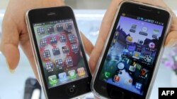 Мобильные телефоны Galaxy Samsung Electronics 'S (справа) и iPhone 3G от Apple в магазине электроники в Сеуле.