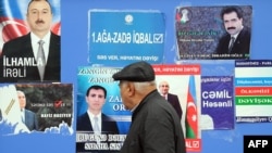 Bakıda prezidentliyə namizədlərin təşviqat plakatları vurulmuş lövhə. 2013