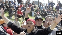 Люди скандируют лозунги во время митинга в селе Нижняя Алаарча близ Бишкека, 20 апреля 2010 года.