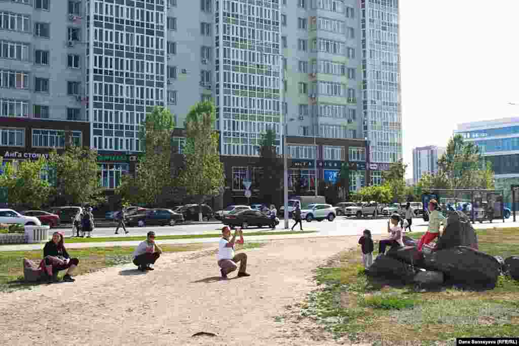 Люди фотографируются на фоне городских пейзажей в Астане.