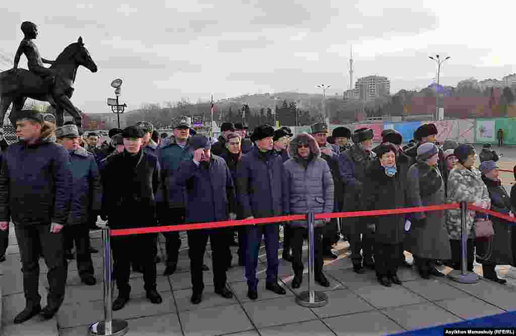 Чиновники во главе с акимом Алматы Бауржаном Байбеком (в центре) на церемонии возложения цветов к монументу Независимости. Алматы, 16 декабря 2018 года.